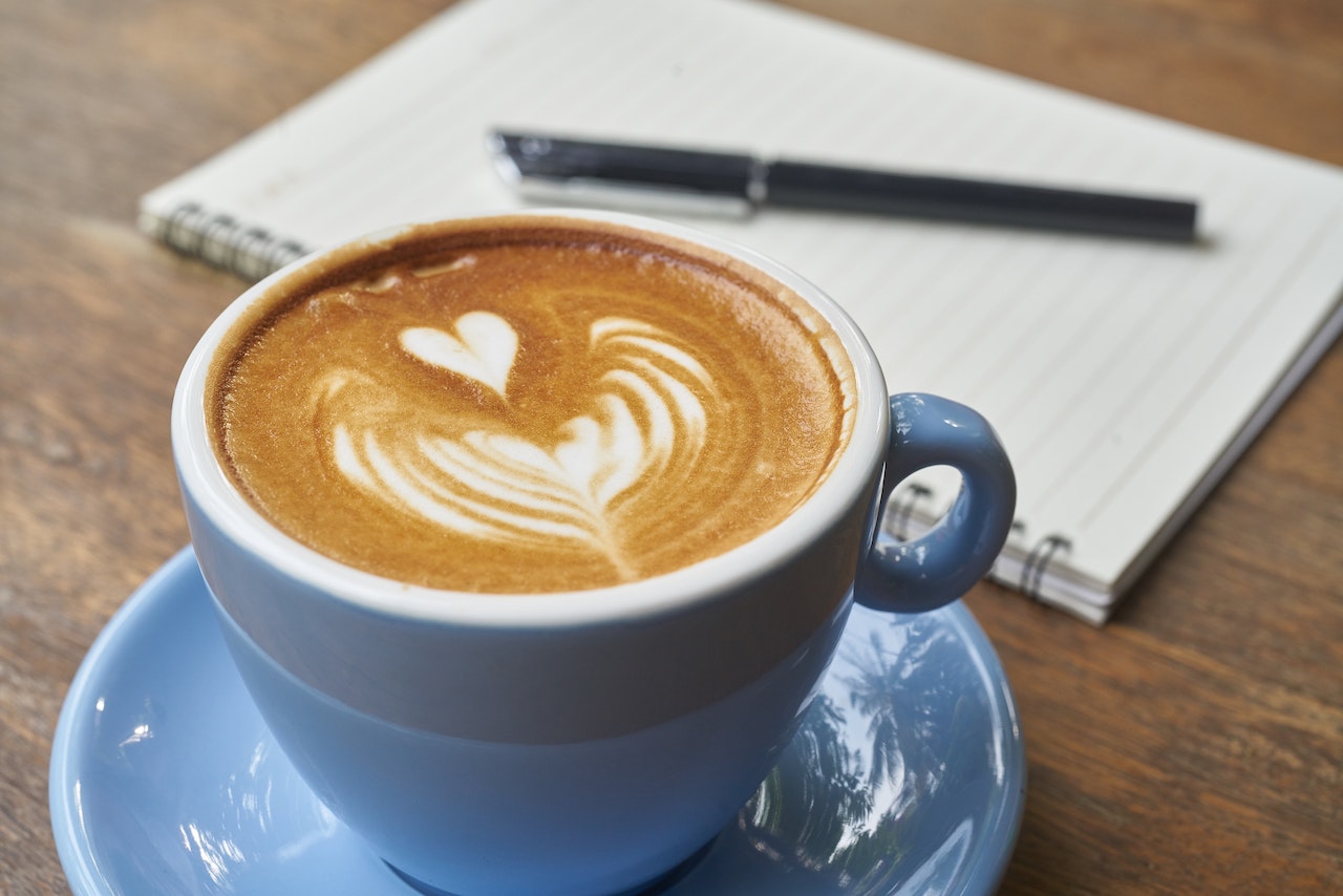 Coffee Latte Beside Notebook
