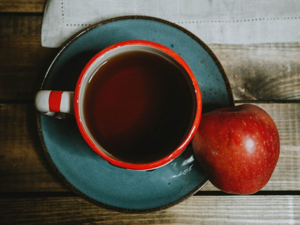 A cup of coffee and an apple