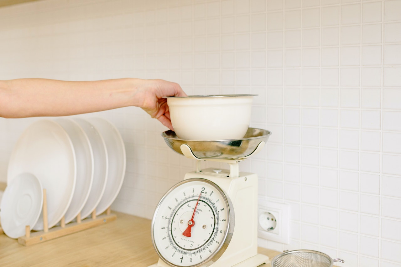 A Person Weighing Ingredients on the Bowl
